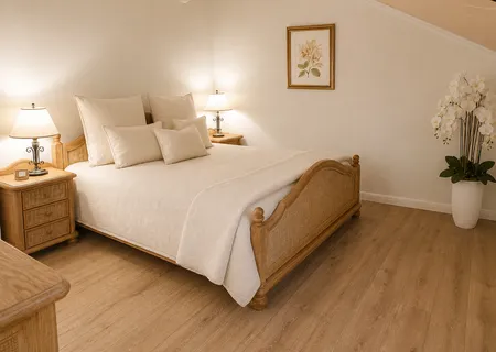 Schlafzimmer der Ferienwohnung Am Wäldchen mit großem Bett und Kommode